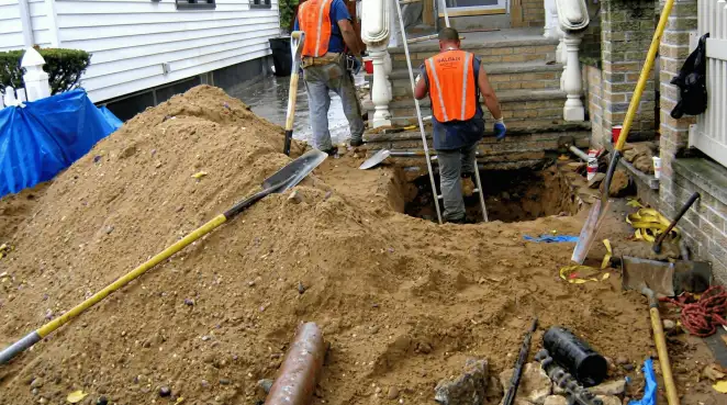Contractors performing foundation protection and exterior drainage excavation near residential home steps in Lincoln, NE